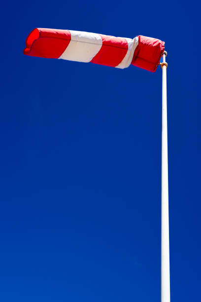 windsock en funcionamiento con un fuerte fondo de cielo azul. - windsock sky natural phenomenon gale fotografías e imágenes de stock