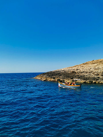 Tourists in traditional Dghajsa water taxi boats at the departure point in the bay, Blue Grotto, Malta, Europe