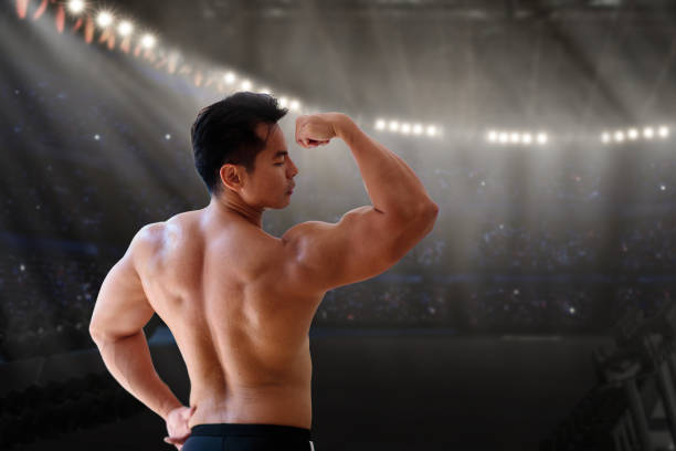 Man exercising in gym. Asian bodybuilder lifting weights. Sport and healthy activity for young male. Active Chinese athlete in training. Body building exercise work out.