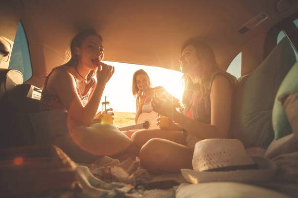 istock Three best friends having fun at the back of a vehicle while making a road trip 1398006523