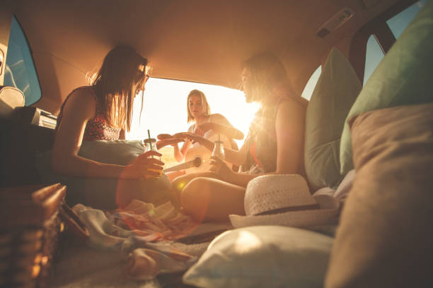 istock Girlfriends having fun while camping in the car trunk
during sunset 1398006525