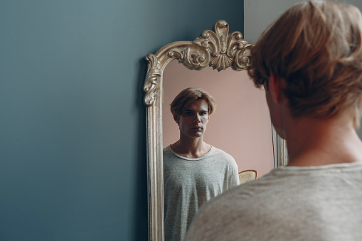 Portrait european young man with mirror portrait at studio indoor