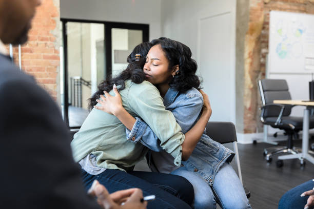 istock Young women embrace each other during a group therapy session 1398008759