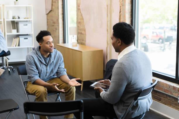 Young adult man meets with academic counselor