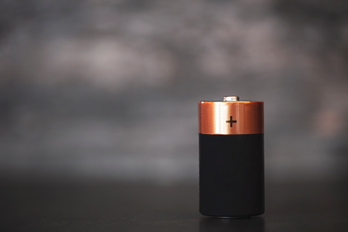 C size alkaline battery on dark blury background