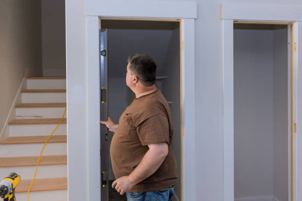 istock Carpenter at interior wood door installation working with level 1398012631