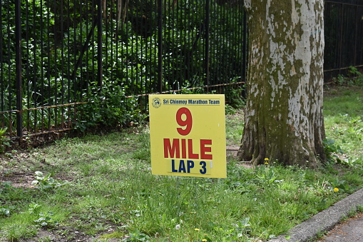 Flushing, Queens, New York, USA - May 14, 2022 - A sign showing the 9 mile or lap 3 mark in the Flushing Meadows Corona Park.
