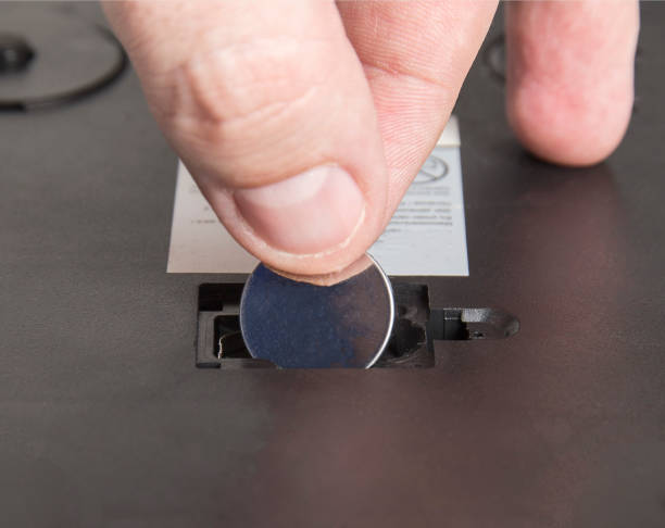 istock Installing a new round coin cell battery in an electrical appliance. Replacing a dead battery, macro. 1398013234