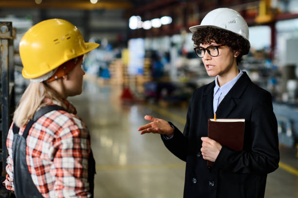 istock Confident female manager explaining something to young engineer at meeting 1398013388