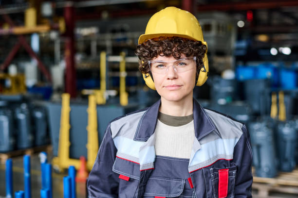 istock Young confident female engineer wearing uniform, hardhat and headphones 1398013480