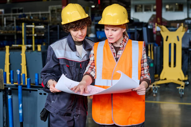 istock Two workers of modern factory wearing protective helmets and workwear 1398013492
