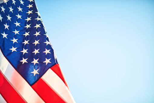Memorial Day background with American flag with blue sky and space for text