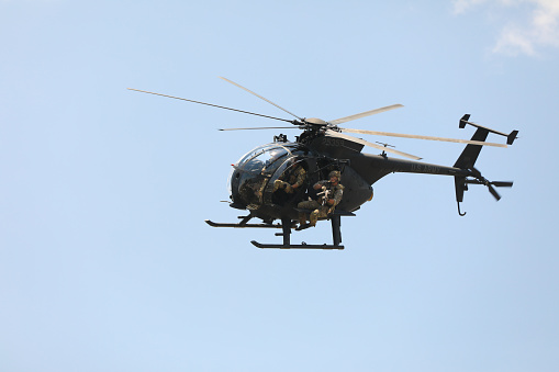 Silhouettes of khaki helicopters with red stars on background of cloudy gray clouds. Four helicopters are flying in battle formation in dark stormy sky.
