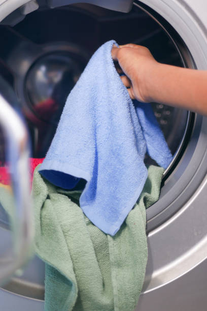 istock putting towel and cloths in a washing machine. 1398018932