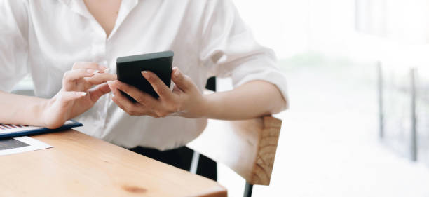 istock Close up hand of woman using smartphone at office. 1398019946