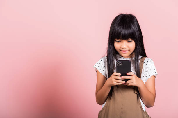 istock Asian kid 10 years enjoying using mobile phone for social network media 1398021485