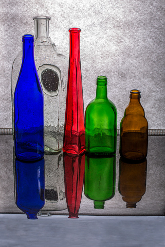 Still life with glass multicolored dishes on a gray background
