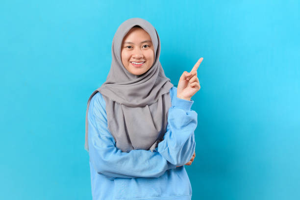 istock Happy young Asian woman pointing at copy space 1398030406