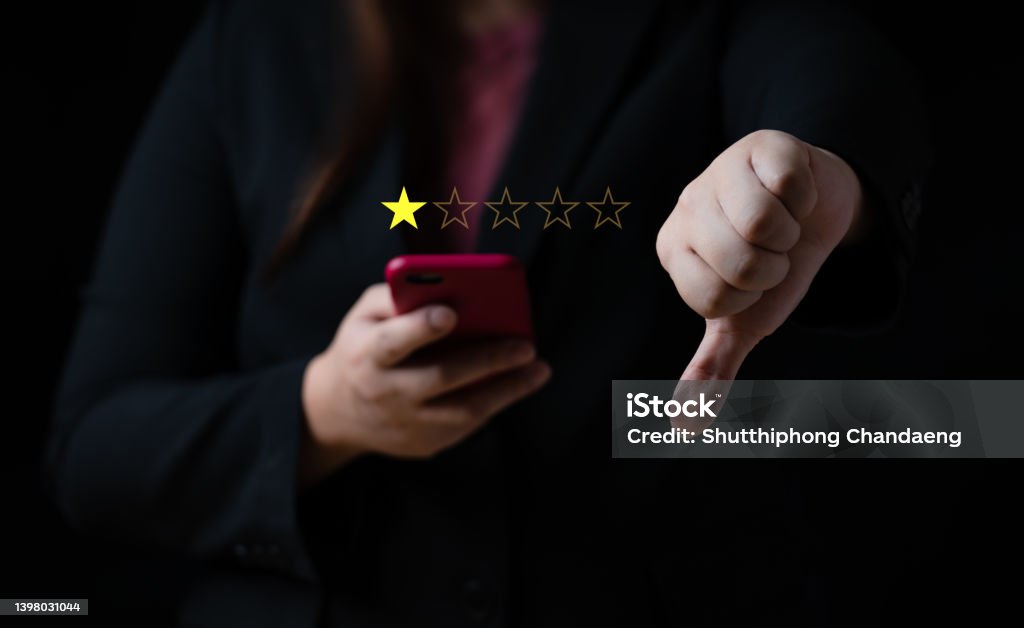 Business women select bad face emoticon on virtual touch screen at smartphone. Bad review, bad service dislike bad quality, low rating, social media not good Dislike Button Stock Photo