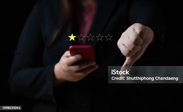 Business Women Select Bad Face Emoticon On Virtual Touch Screen At Smartphone Bad Review Bad Service Dislike Bad Quality Low Rating Social Media Not Good Stock Photo - Download Image Now