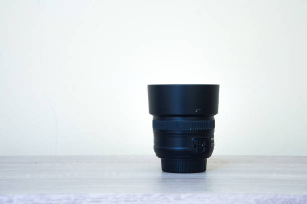 istock 50mm lens camera on wood table and white background 1398034611