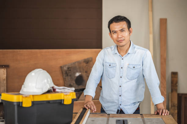 istock Happy male carpenter with circular power saw on workbench, Carpenter working on woodworking machines in carpentry shop 1398036927