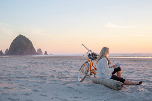 Mature woman uses digital tablet, on beach