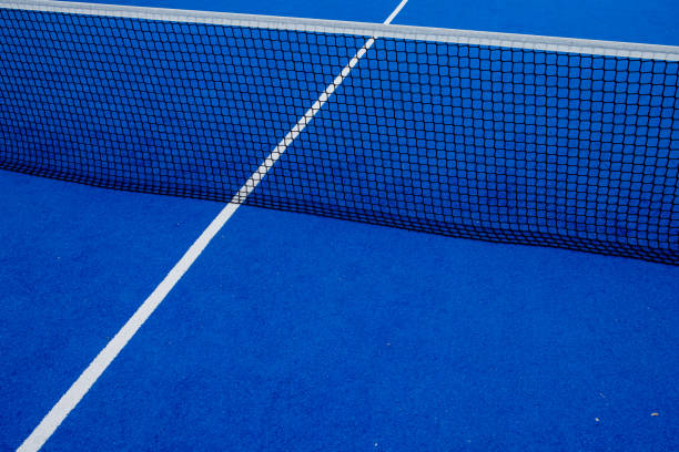 blick auf das netz eines blauen kunstrasen-paddle-tennisplatzes. - court building stock-fotos und bilder