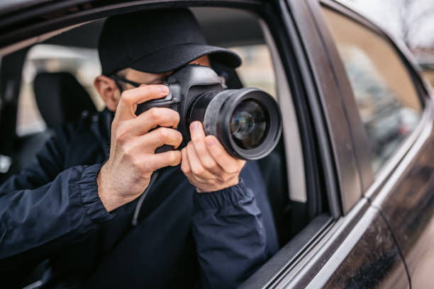 車から写真を撮るパパラッチ写真家 - 探偵 ストックフォトと画像