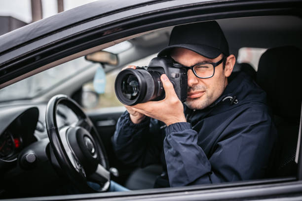 istock Private Detective Taking Photos At Stake-out 1398047223