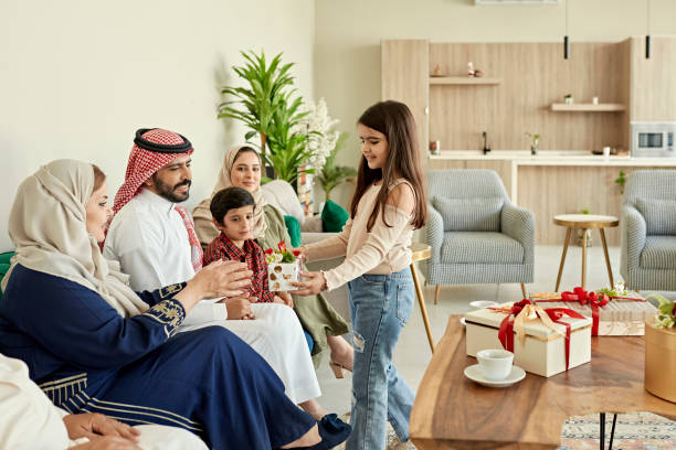 famiglia saudita che scambia regali per la festa di eid-ul-fitr - saudi arabia child ramadan offspring foto e immagini stock