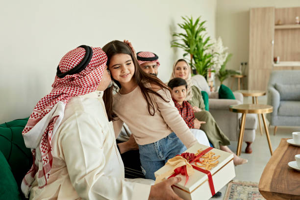 famiglia mediorientale insieme per lo scambio di regali eid-ul-fitr - saudi arabia child ramadan offspring foto e immagini stock