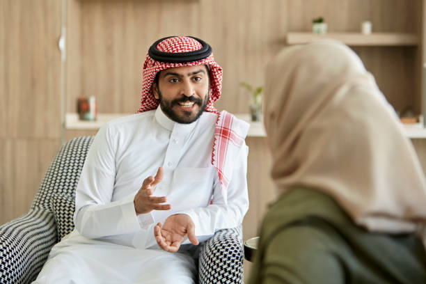 Middle Eastern man and woman conversing in family home stock photo