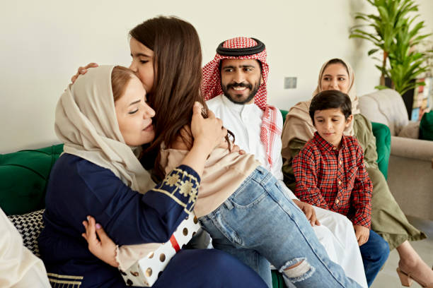 donna saudita che abbraccia la nipote durante la riunione di famiglia - saudi arabia child ramadan offspring foto e immagini stock