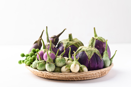 Various eggplant or aubergine in basket on white background, Organic vegetables