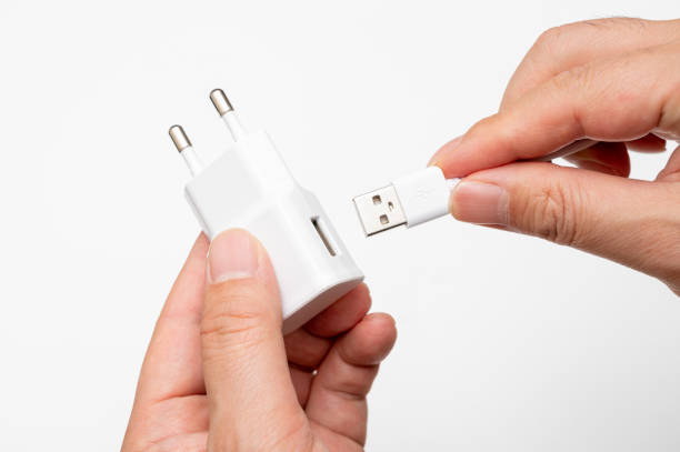 istock Male hand connecting USB cable to charging adapter. 1398049197