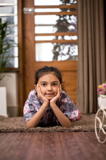 istock Happy little girl lying down at home 1398050171
