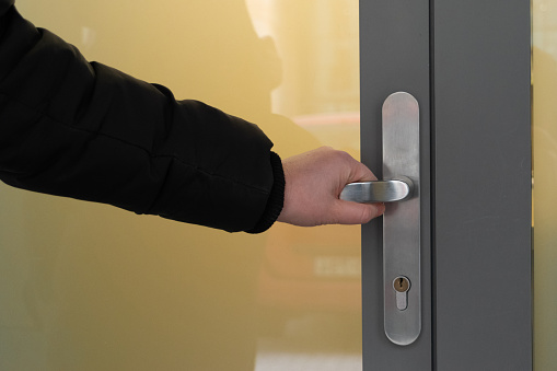 Hand hold door handle. Holding doorknob, business person opens glass door, office street enter