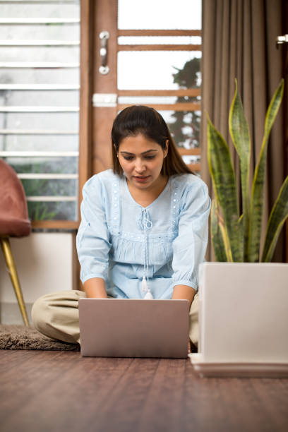 istock Young woman using laptop at home 1398050652