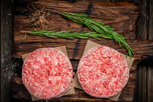 Organic raw minced meat or beef cutlets on a wooden Board