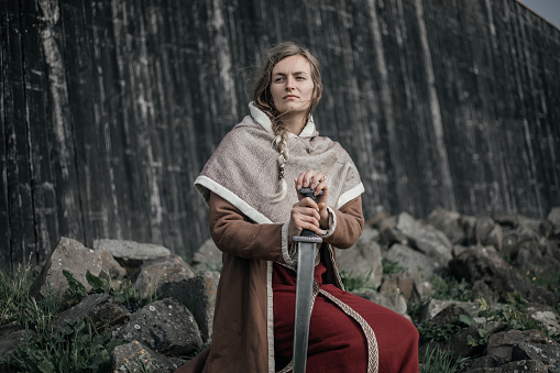 A Beautiful blonde Viking Woman outdoors on a settlement