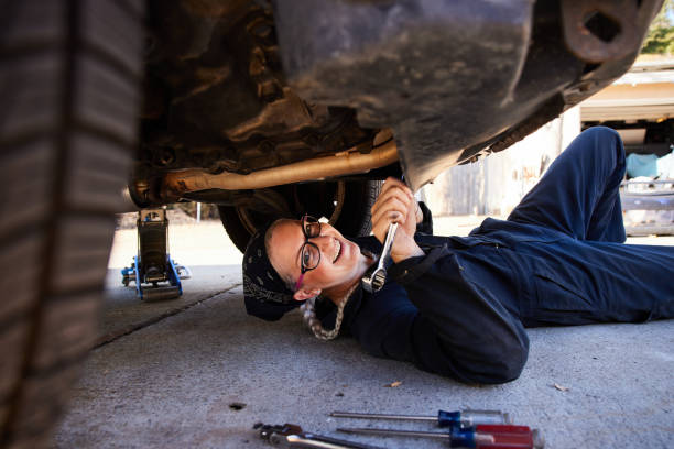 istock Smiling young female mechanic working underneath a car 1398054181