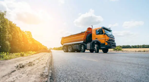 Dumper truck ready to unload soil or groud at construction site. Road service build a new highway