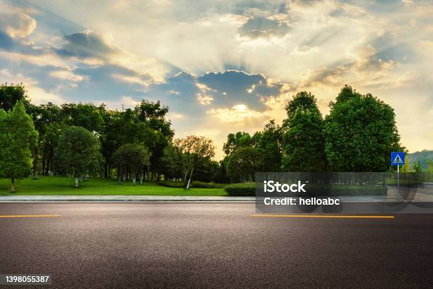 Empty Asphalt Road Near Park With Explosive Sunshine In The Sky During Sunrise Stock Photo - Download Image Now