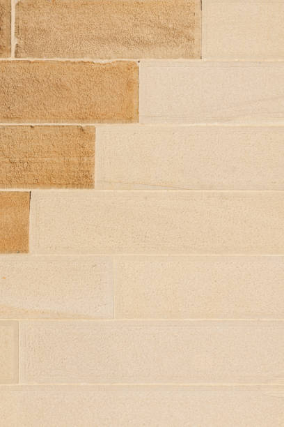 Part of a two tone sandstone block wall