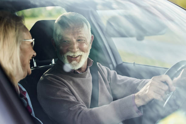 istock Happy senior couple talking while going on a trip by car. 1398058182