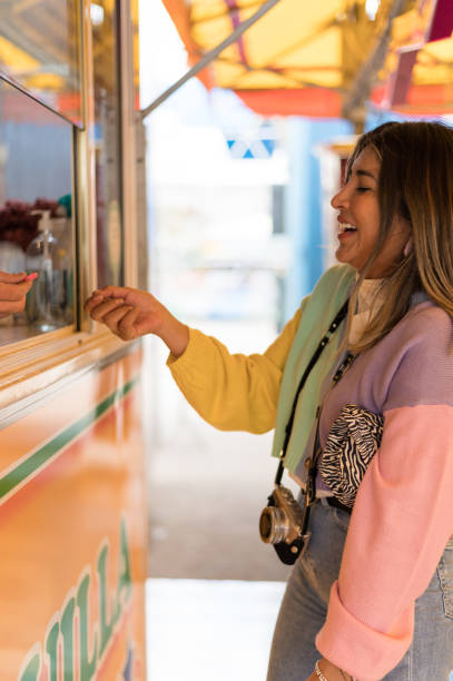 istock Optimistic female buying tokens during fair 1398058544