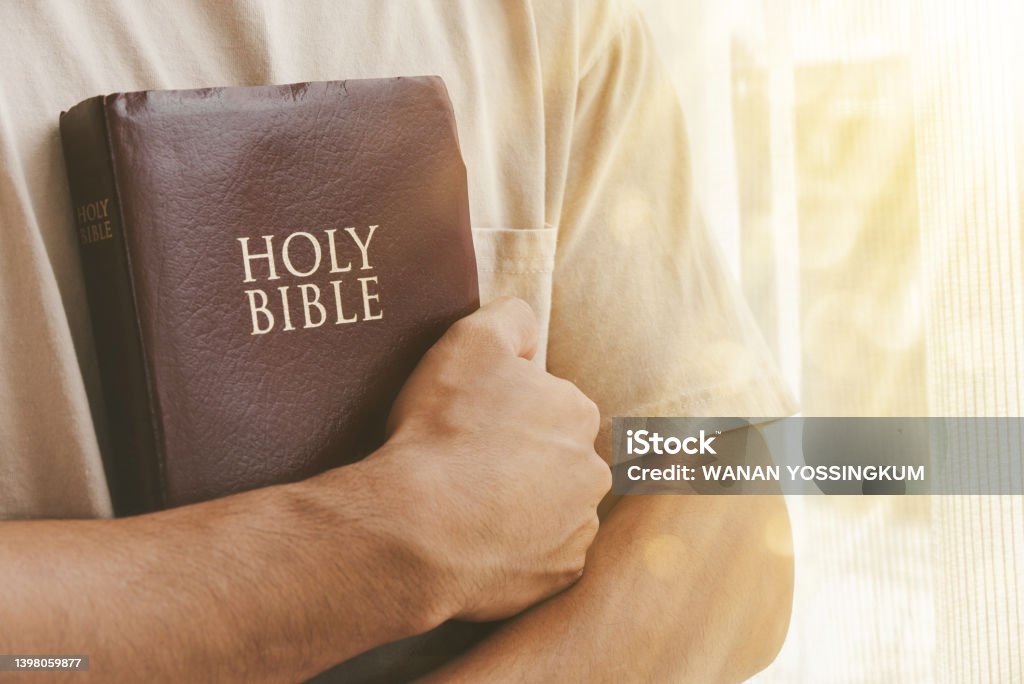 Christian life, faith, hope, trust in God Man hugging the bible in the morning. Concept, faith, hope, trust in God. Bible Stock Photo