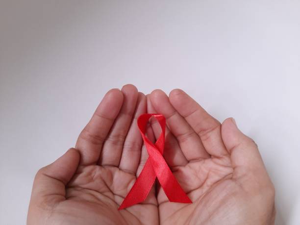 istock Hands and a red ribbon. AIDS awareness symbol 1398061314