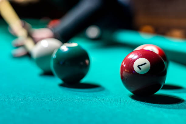 istock Old billiard ball and stick cue on a green table. 1398061423